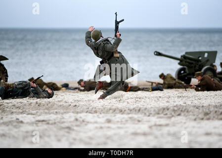 Soldati combattono sulla spiaggia durante la ricostruzione della storica battaglia con la seconda guerra mondiale Foto Stock
