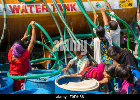 Persone acqua di riempimento in fusti di plastica da acqua petroliera Bhiwandi, Maharashtra, India Foto Stock