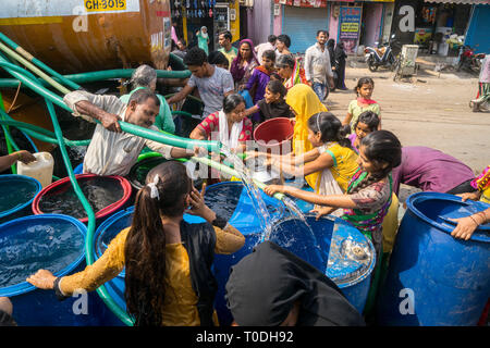 Persone acqua di riempimento in fusti di plastica da acqua petroliera Bhiwandi, Maharashtra, India Foto Stock