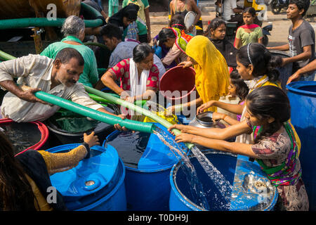 Persone acqua di riempimento in fusti di plastica da acqua petroliera Bhiwandi, Maharashtra, India Foto Stock