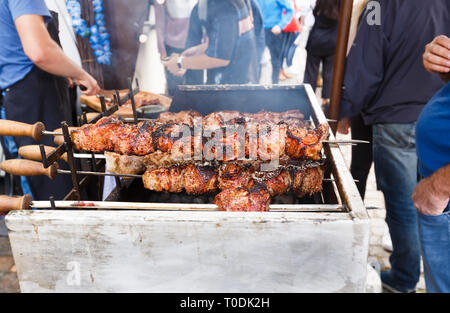 Barbecue spiedini sulla griglia aperta, le persone che attendono il cibo gustoso. Foto Stock