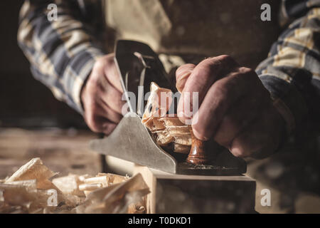 Le mani di un falegname lavora con un utensile di piallatura Foto Stock