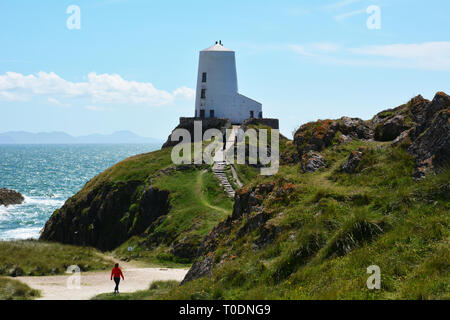 In cammino verso l'iconica Twr Mawr faro sull isola di Llanddwyn che è situato sulla costa di Anglesey nel Galles del Nord. Foto Stock