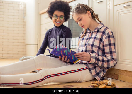 Allegro international ragazzo seduto vicino al suo amico Foto Stock