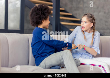 Scioccato adolescente bionda fissando il suo amico Foto Stock
