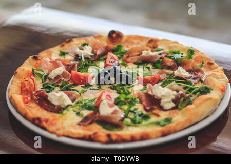 Pizza con pomodoro, salumi e olive Foto Stock