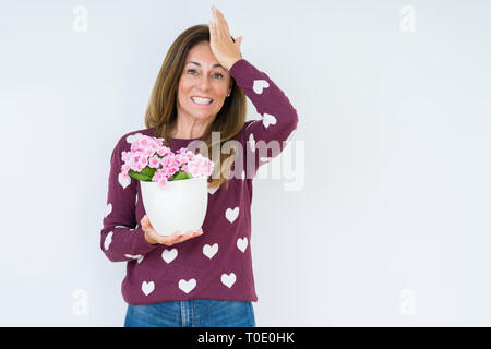 Medio Evo Woman holding fiori piante pot su sfondo isolato ha sottolineato con la mano sulla testa, sconvolto con vergogna e la sorpresa di fronte, arrabbiato e frustr Foto Stock