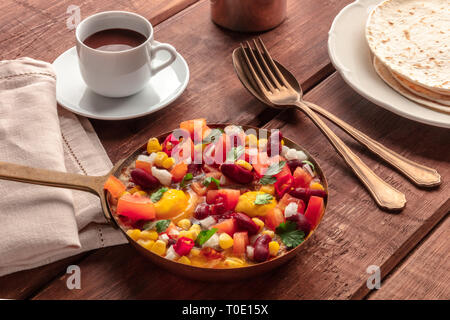 Colazione messicana cibo. Huevos rancheros, le uova fritte con il Pico de Gallo insalata, cioccolata calda e tortillas Foto Stock