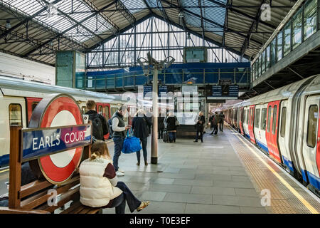 I treni della District Line sono in attesa presso i binari della stazione metropolitana di Earls Court , Londra, Regno Unito Foto Stock