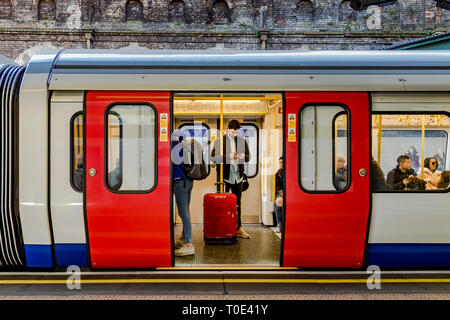 Persone su un treno District Line/Circle Line in attesa che le porte siano chiuse alla stazione della metropolitana di Sloane Square, Londra, Regno Unito Foto Stock