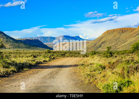 La ghiaia strada di montagna nel cielo blu, Karoo National Park in estate, provincia del Capo occidentale del Sud Africa. Foto Stock