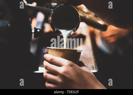 Latte, caffè Barista rendendo caffelatte in coffee shop Foto Stock