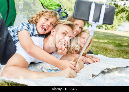 I bambini assumono un selfie di se stessi e delle loro famiglie durante il periodo estivo le vacanze in campeggio Foto Stock