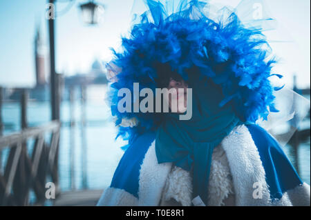 Donna mascherata con un blu piume hat durante il carnevale di Venezia Foto Stock