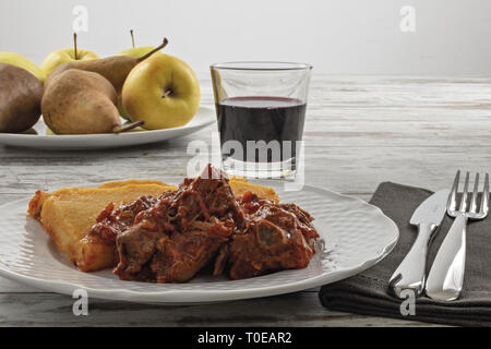 Piatto con polenta e carne al sugo di pomodoro fronte Foto Stock