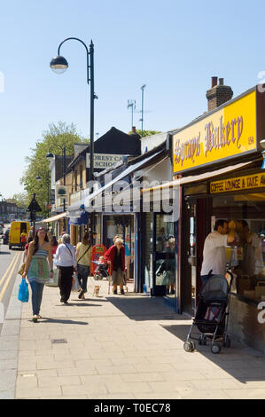 Persone che camminano giù il high street in botesdale, Essex. Foto Stock