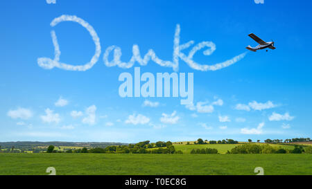 Aeromobile scrive parola tedesca 'Danke' (grazie) in grafia in cielo come un ringraziamento Foto Stock