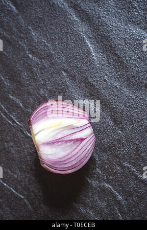 Cipolla rossa mezza, dettagli di texture e pattern, in metallo di colore nero. scheda di sani ingredienti alimentari. piatto da laici al di sopra Foto Stock