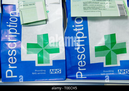 Sacchetti di carta di NHS prescrizioni pronto a raccogliere con la prescrizione attaccato al ID il contenuto. Foto Stock