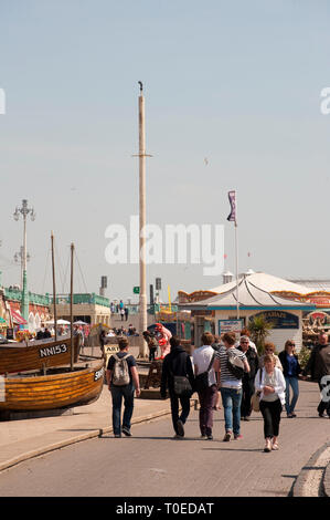 La gente camminare lungo la passeggiata al di fuori del museo della pesca nella cittadina balneare di Brighton, Sussex. Foto Stock