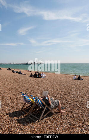 Persone relax sulla spiaggia in una giornata di sole in Brighton, Sussex, Inghilterra. Foto Stock