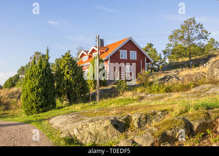 Cottage rosso sull'isola Harstena in Svezia, conosciuta principalmente per la caccia alle foche che era una volta effettuata vi. Ora è un'attrazione turistica. Foto Stock