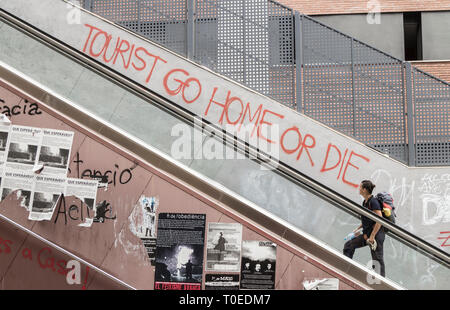 'Tourist go home or die' a muro vicino scala mobile a Barcellona, Spagna. Concetto di coronavirus... Foto Stock