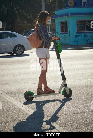 Equitazione donna un elettrico e scooter a noleggio, South Congress Avenue, Austin, Texas Foto Stock