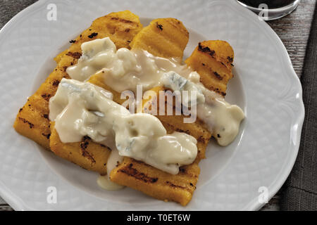 Piatto con polenta e formaggio gorgonzola dall'alto. primo piano Foto Stock