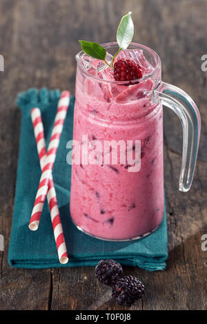 Fresh Berry smoothie e carta paglia sul tavolo di legno Foto Stock