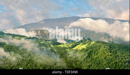 Il paesaggio tipico della campagna georgiana nel Caucaso pedemontana all'alba attraverso la mattina nuvole basse vicino Nikortsminda, Racha regione della Georgia Foto Stock