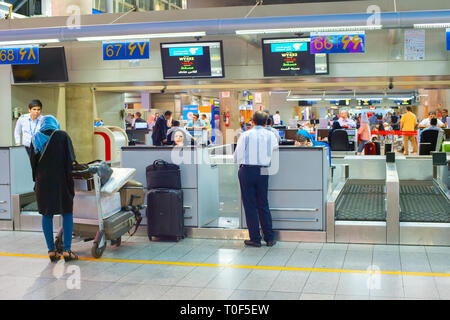 TEHRAN, IRAN - 23 Maggio 2017: uomo e donna con i bagagli presso il banco di check-in, Tehran Imam Khomeini International Airport Foto Stock