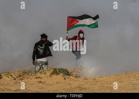 Marzo 19, 2019 - Gaza, Palestina, 19 marzo 2019. Un numero di palestinesi sono ferito da israeliani fuoco vivo e gas lacrimogeni durante scontri a nord di Beit Lahia nel nord della Striscia di Gaza, vicino il Gaza-Israel recinzione marittima. Centinaia di palestinesi sono state tenendo il venticinquesimo protesta contro il popolo israeliano blocco navale e l assedio a Gaza, con alcuni manifestanti che lanciano pietre verso il recinto e secondo alla striscia di Gaza del Ministero della sanità almeno 20 manifestanti sono stati feriti da proiettili sparati da soldati israeliani si trova sull'altro lato della recinzione. Durante la protesta, che è stato organizzato da Foto Stock