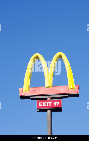 Guardando il McDonalds Golden Arches segno contro un chiaro e profondo cielo blu Foto Stock