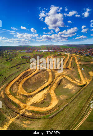 Antenna top down foto della pista di motocross che mostra le alte prestazioni off-road moto racing su disegni manmade circuito sterrato con salto ripido Foto Stock