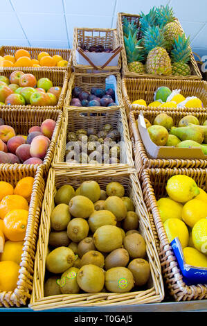 Varie ceste di frutta diversa per la vendita in un negozio di generi alimentari di colore verde. Foto Stock