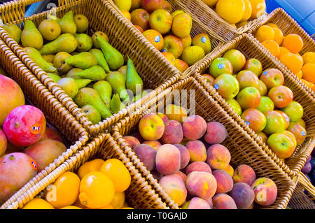 Varie ceste di frutta diversa per la vendita in un negozio di generi alimentari di colore verde. Foto Stock