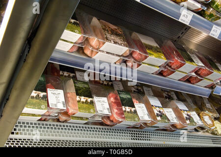 Vari pacchetti di differenti carne biologica per la vendita in un negozio di frigo. Foto Stock