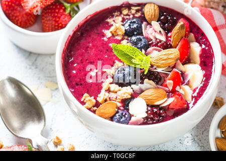 Ciotola Frullato di frutti di bosco freschi, dadi e granola. Foto Stock