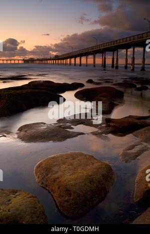 Pacifico, ispirando e tranquillo tramonto, la riflessione di nuvole su Ocean Beach con pier sporgendo in Oceano Pacifico, San Diego, California. Foto Stock