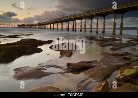 Pacifico, ispirando e tranquillo tramonto, la riflessione di nuvole su Ocean Beach con pier sporgendo in Oceano Pacifico, San Diego, California. Foto Stock