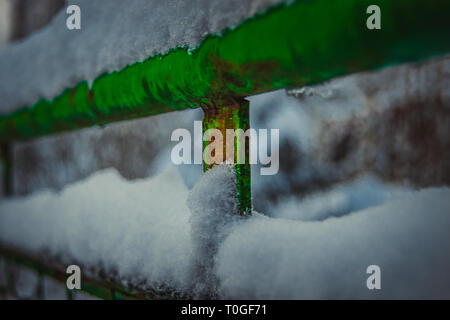 Coperte di neve elemento del vecchio recinto verde. L'inverno è passato e la neve è rimasta. Foto Stock