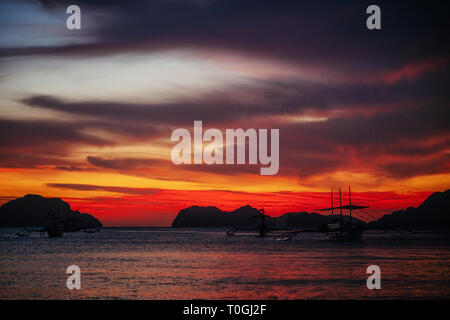 Tradizionali barche filippina in Corong-Corong spiaggia di El Nido al tramonto le luci. Isola di Palawan, Filippine Foto Stock