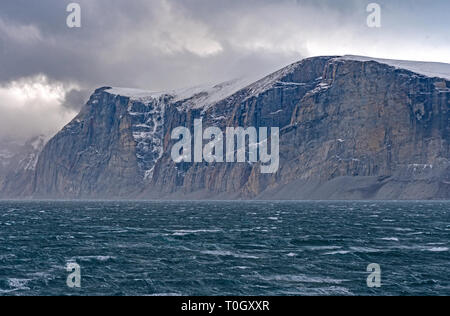 Scogliere a picco sul mare al di sopra di tempesta si lancia mari in Sam Ford Fjord sull Isola Baffin in Nunavut, Canada Foto Stock