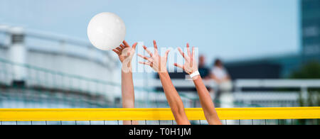 Le mani a giocare a beach volley Foto Stock