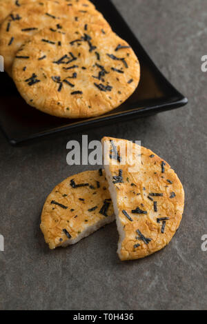 Il piatto con il tradizionale intero e dimezzato cracker di riso giapponesi e nori alghe marine Foto Stock