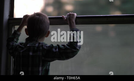 Felice ragazzo è il viaggio in treno di sera, guardando fuori dalla finestra Foto Stock