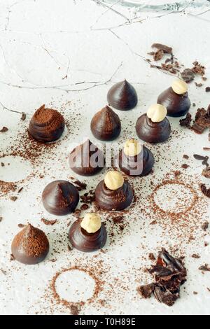 La cottura di tartufi di cioccolato vicino sul tavolo. Le sfere di cacao, cioccolato sfere torte spruzzata con la polvere di cacao con nocciole. Foto Stock