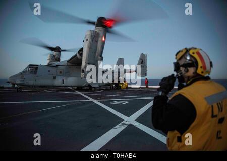 Oceano Pacifico (16 marzo 2019) - Aviazione di Boatswain Mate (manipolazione) 1a classe Pietro Obeng comunica con la torre di controllo durante le operazioni di volo con un MV-22B Osprey dal mezzo marino Tiltrotor Squadron 164 sul ponte di volo della USS New Orleans (LPD 18) durante l'esercizio pacifico Blitz 19. Pacific Blitz è uno scenario-driven esercizio congiunto che fornisce corsi di formazione pertinenti dalla replica di una realistica minaccia marittima ambiente concepito per stimolare e migliorare la capacità anfibie necessaria per una effettiva crisi globale risposta. (U.S. Foto di Marina di Massa Specialista comunicazione 2° Cla Foto Stock