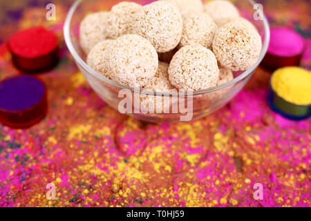 Foto di organico holi colore con cholai ke ladoo nel recipiente di vetro. Isolato su sfondo colorato. Foto Stock